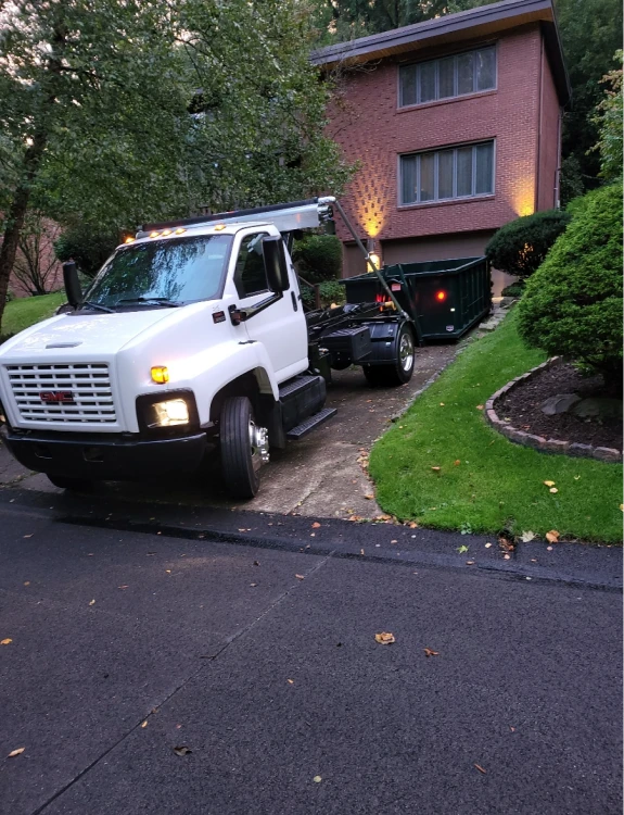 Rented roll-off dumpster in a residential driveway during a cleanup